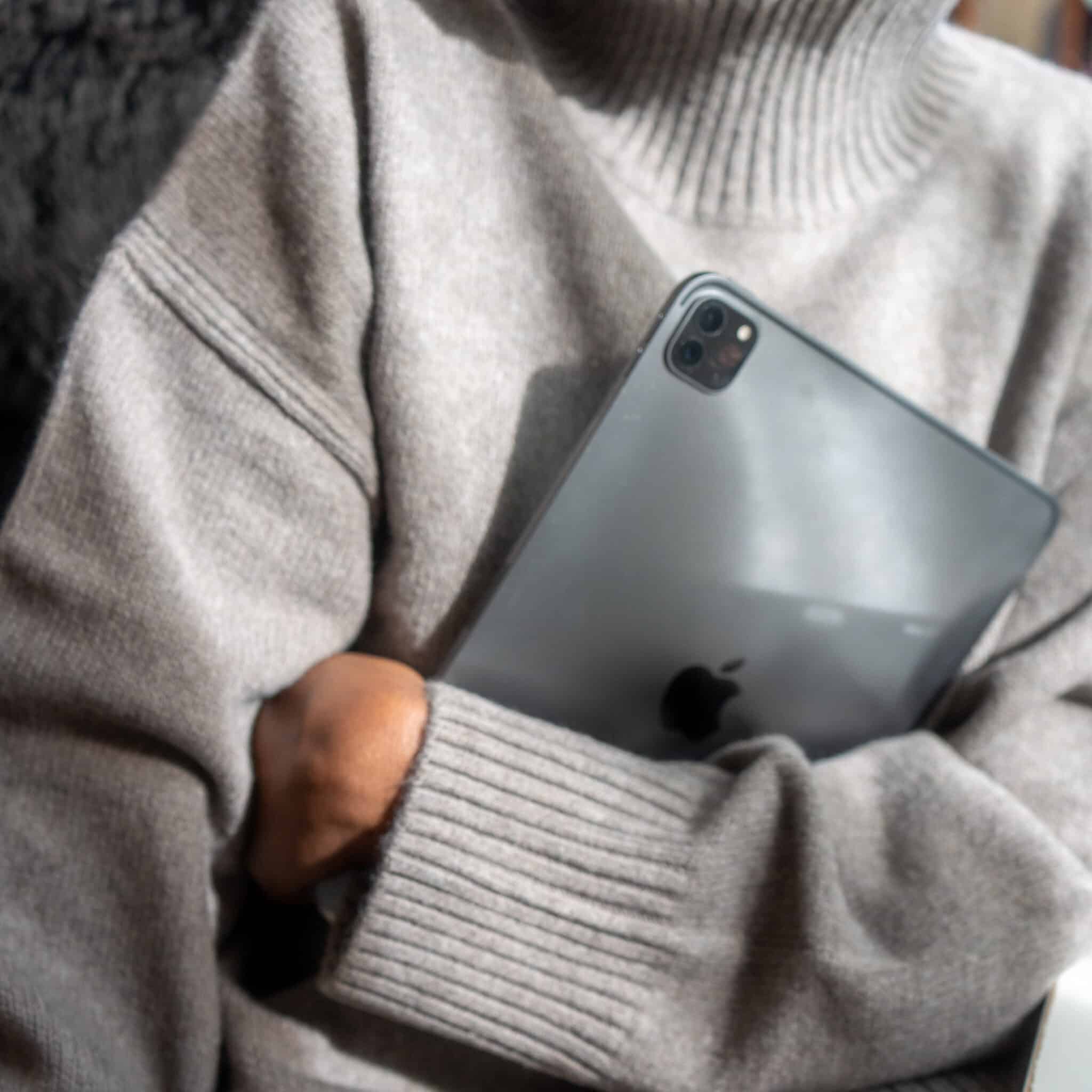 Woman in grey sweater holding an iPad